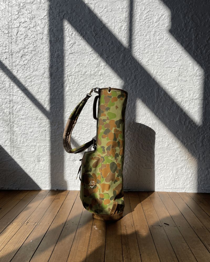 The camo Sunday bag in sunlight on a timber floor