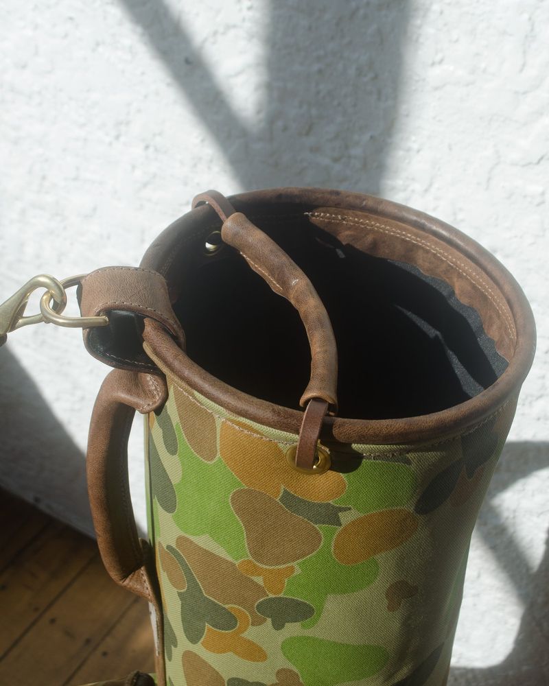 The leather-trimmed top of the camo Sunday bag