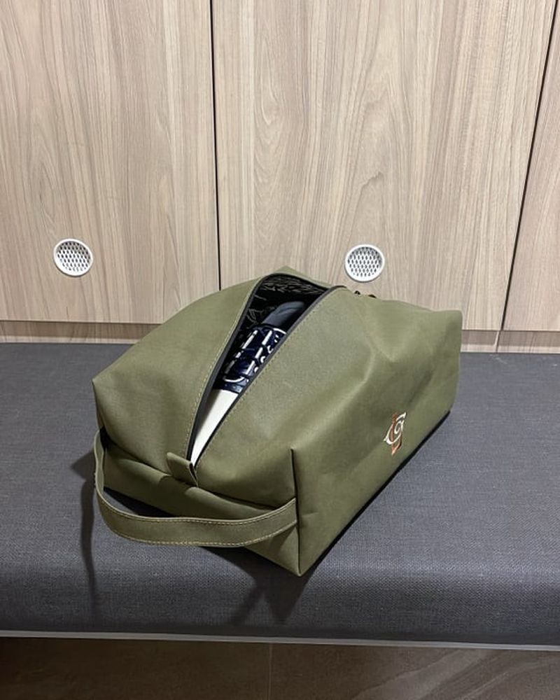 The olive shoe bag unzipped on the bench