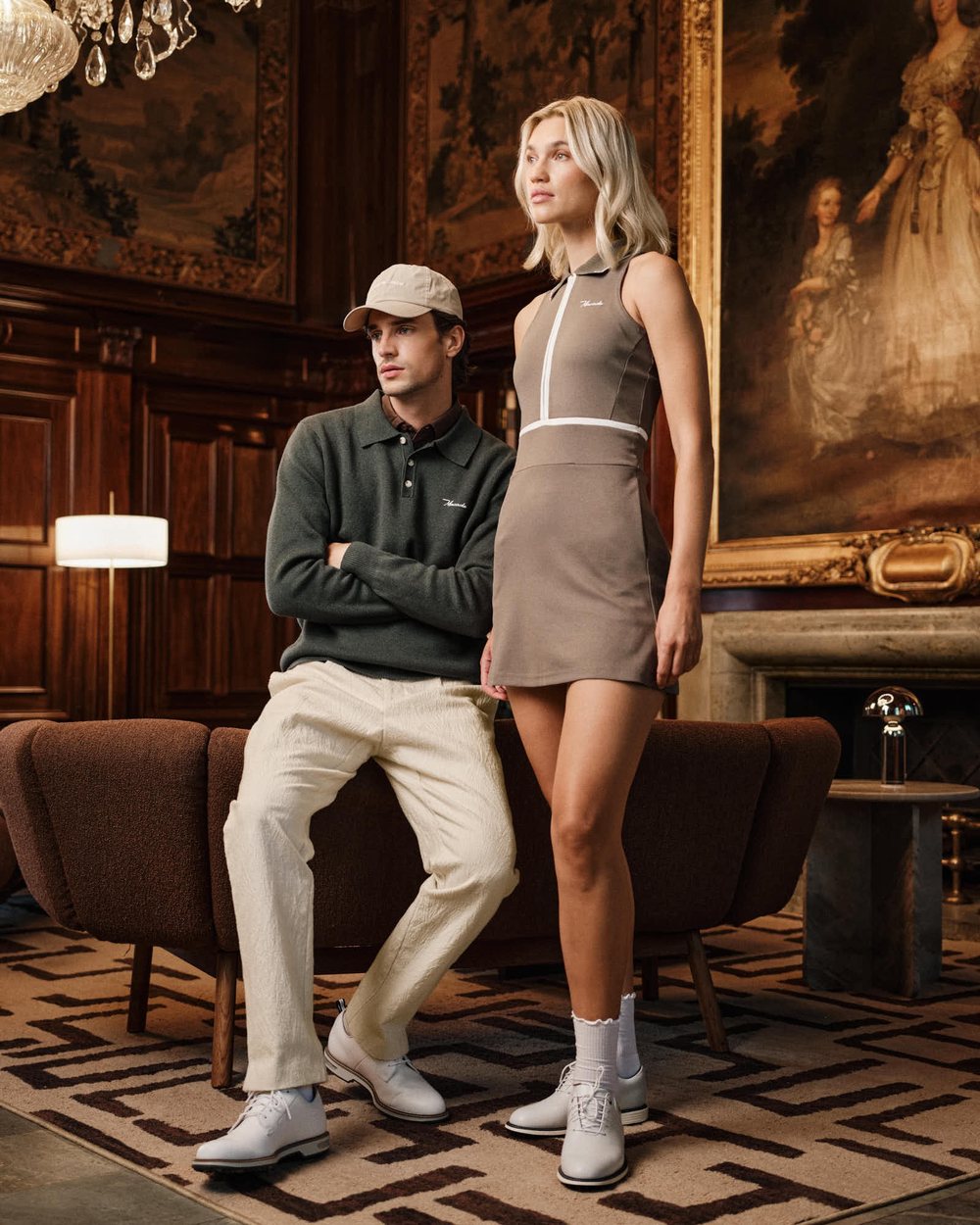 A man and a woman in Macade knitwear in an old library