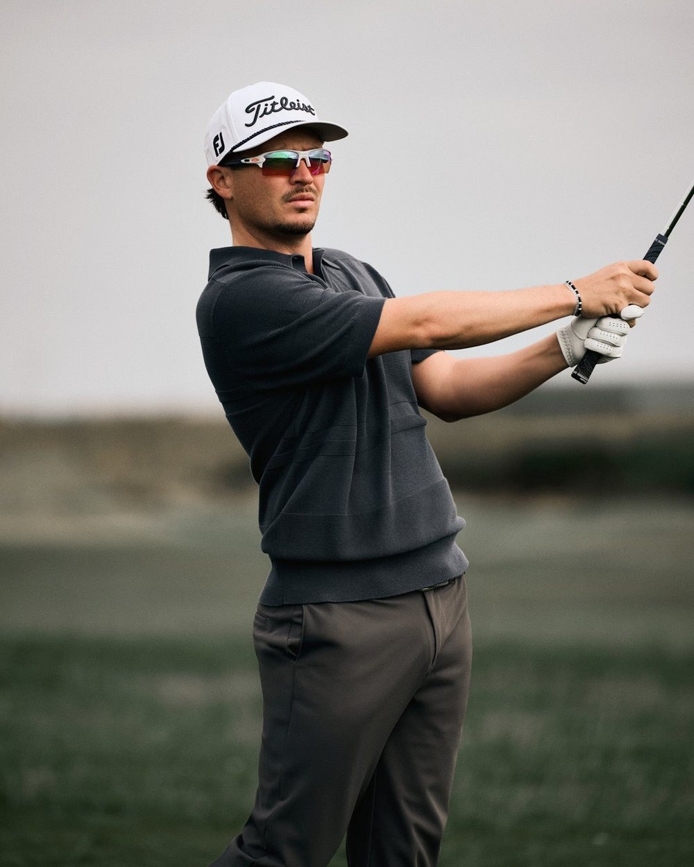 Ewen Ferguson swinging in a dark Macade polo