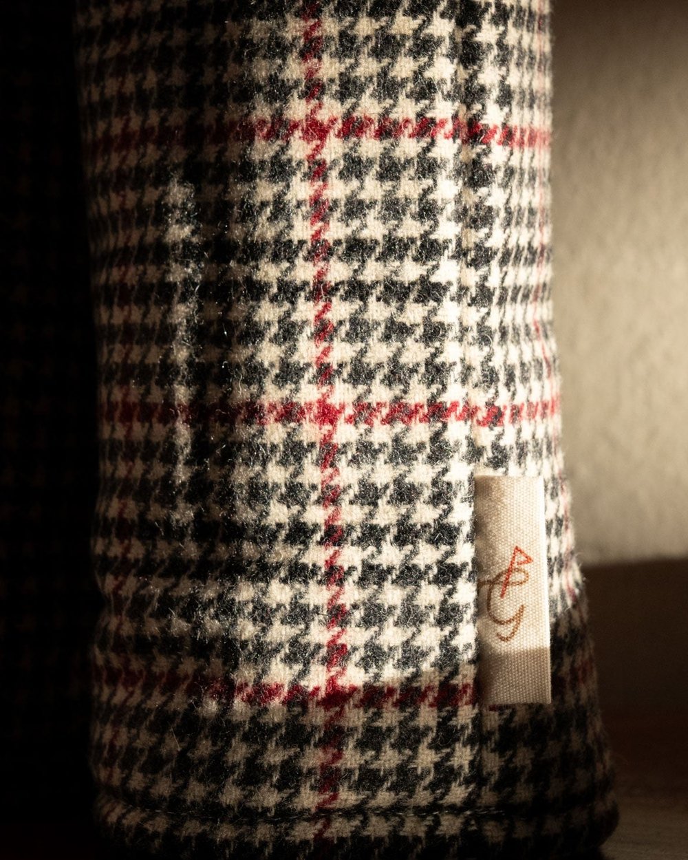 A close-up of a black, white and red houndstooth headcover