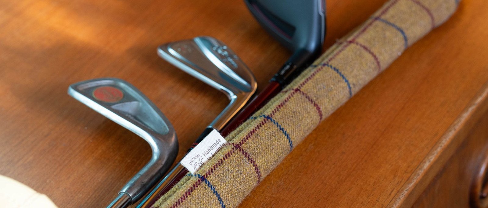 A Mackem check alignment-stick cover lying across a set of irons on a timber table