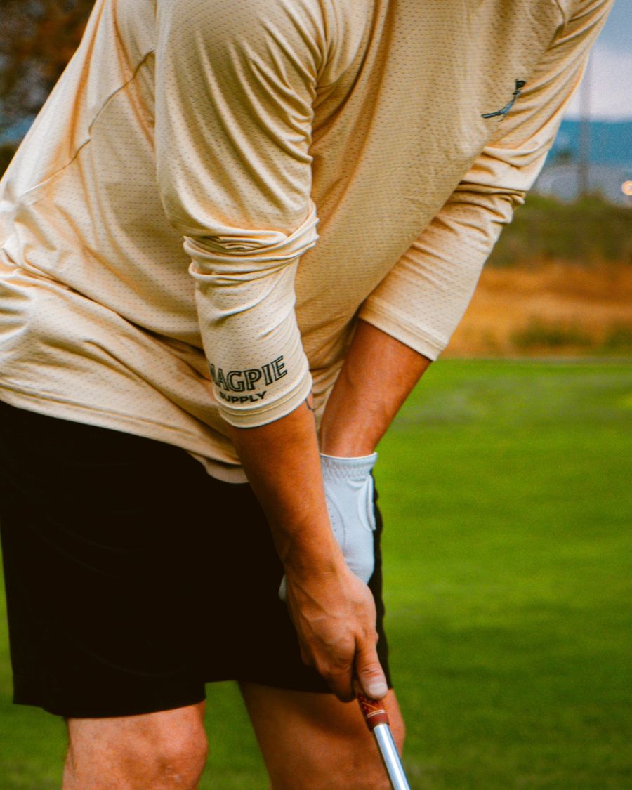 A golfer at address in the Magpie Staple Sun Shirt
