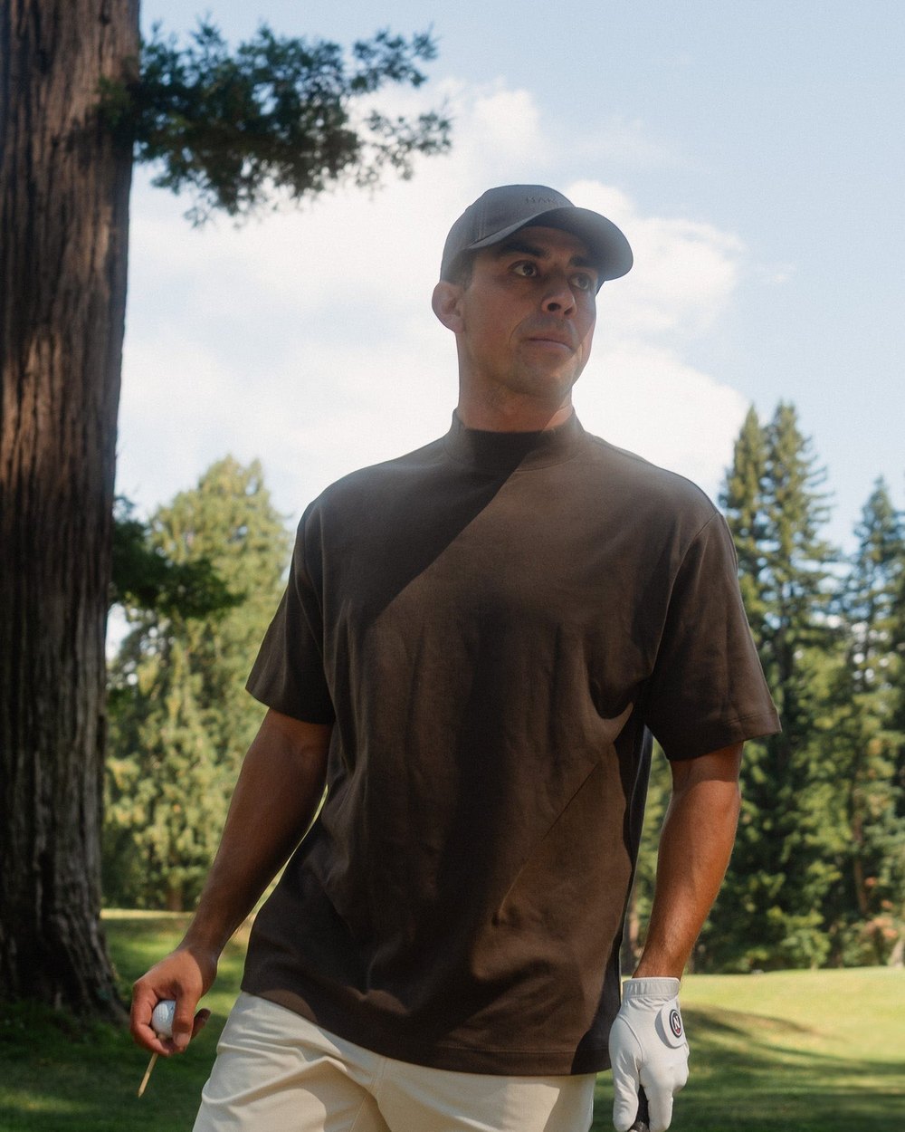 A golfer in a brown Signature mock in a redwood forest