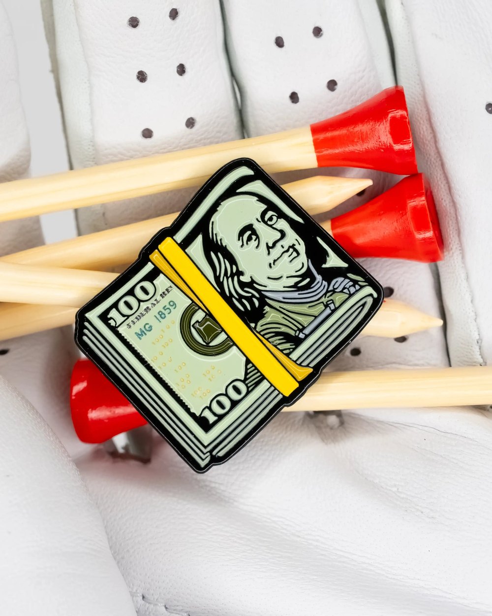 Matchstick Golf's Cash Stack ball marker on tees in a white glove