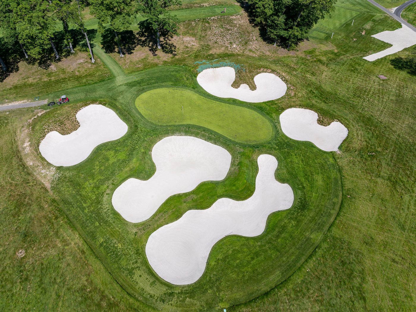 Drone view of a Bethpage green ringed by five big white-sand bunkers