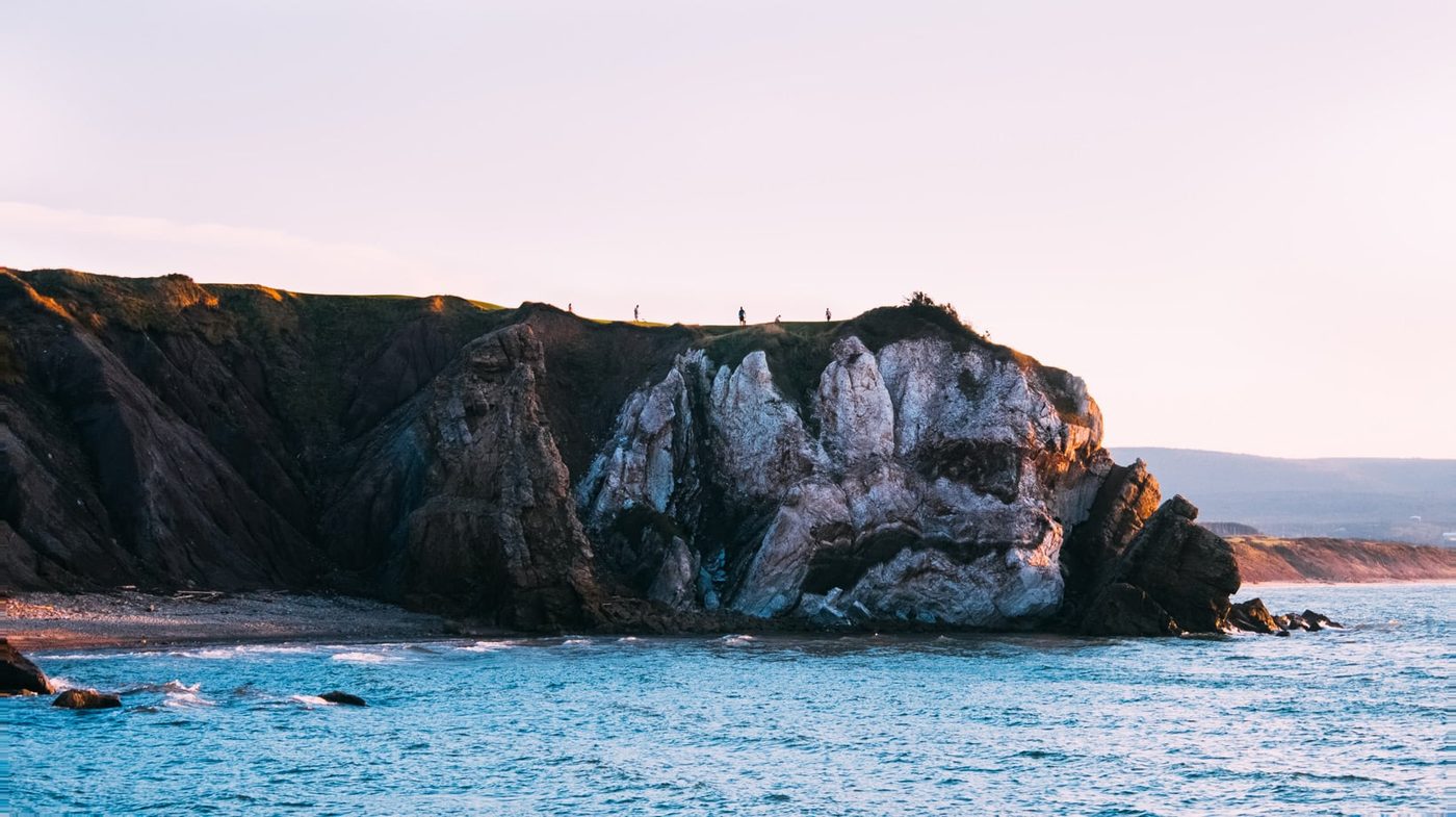 Golfers on the 16th green atop a sheer cliff above the sea
