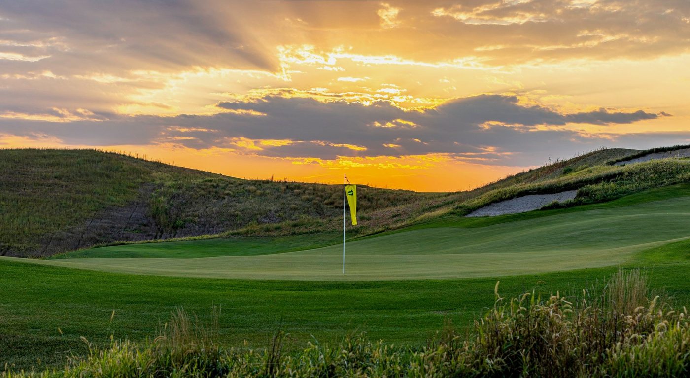 A yellow windsock flag on a Landmand green at sunset