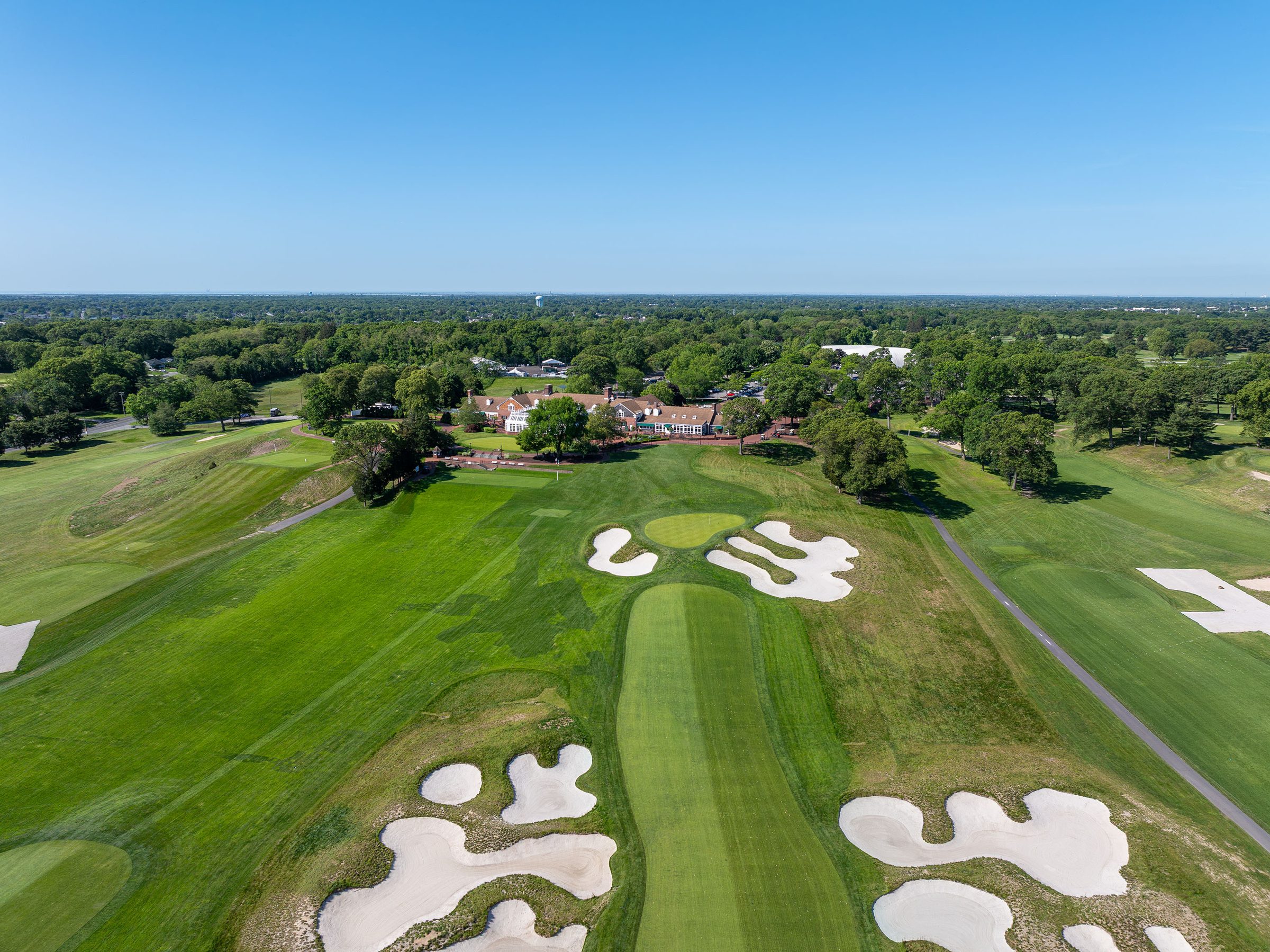 Drone view over Bethpage fairway bunkers toward the clubhouse