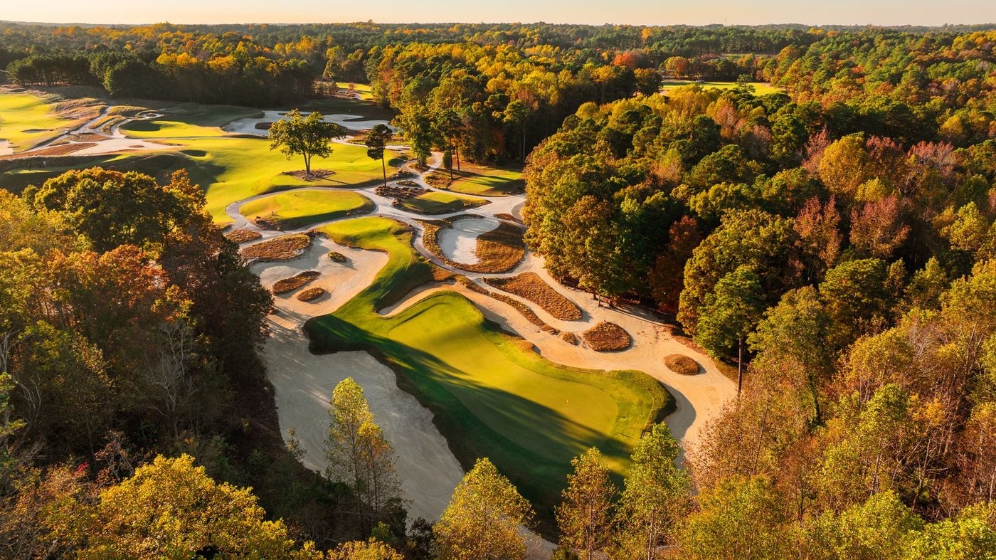 Autumn drone view of Tobacco Road's 3rd green cut into a hillside of orange and gold hardwoods