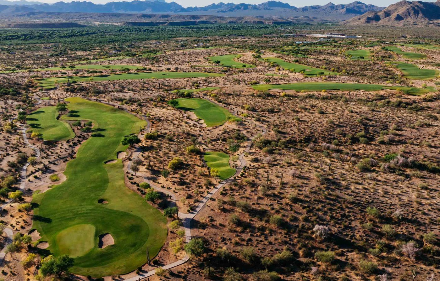 Drone view of narrow fairways threaded through open Sonoran desert