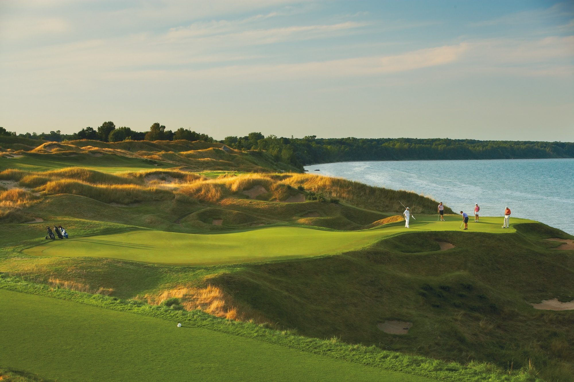 Golfers putting on a green perched on a bluff above Lake Michigan at Whistling Straits