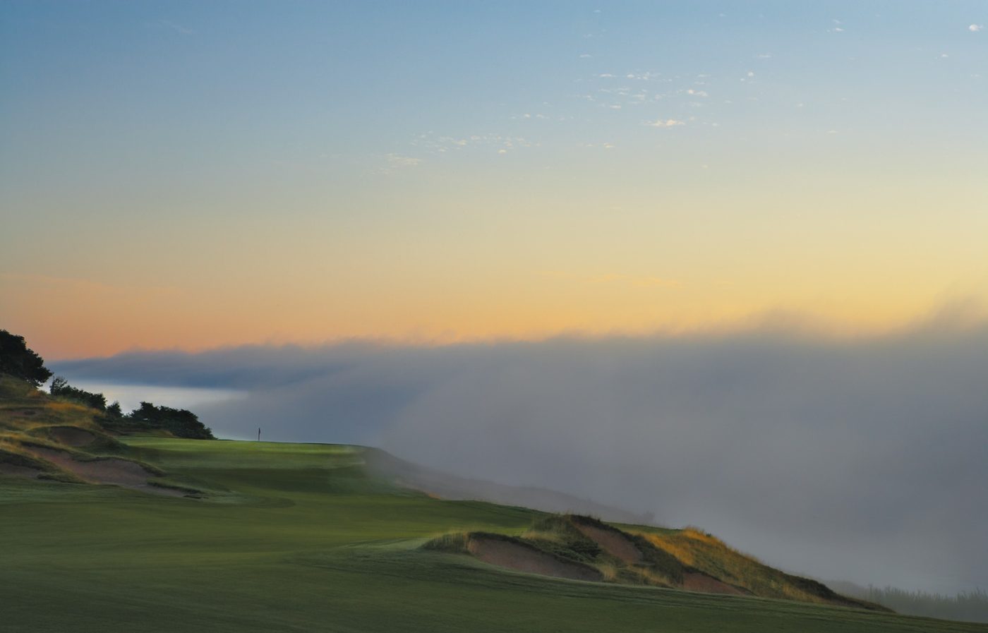 Fog rolling off Lake Michigan over the 8th hole at dawn