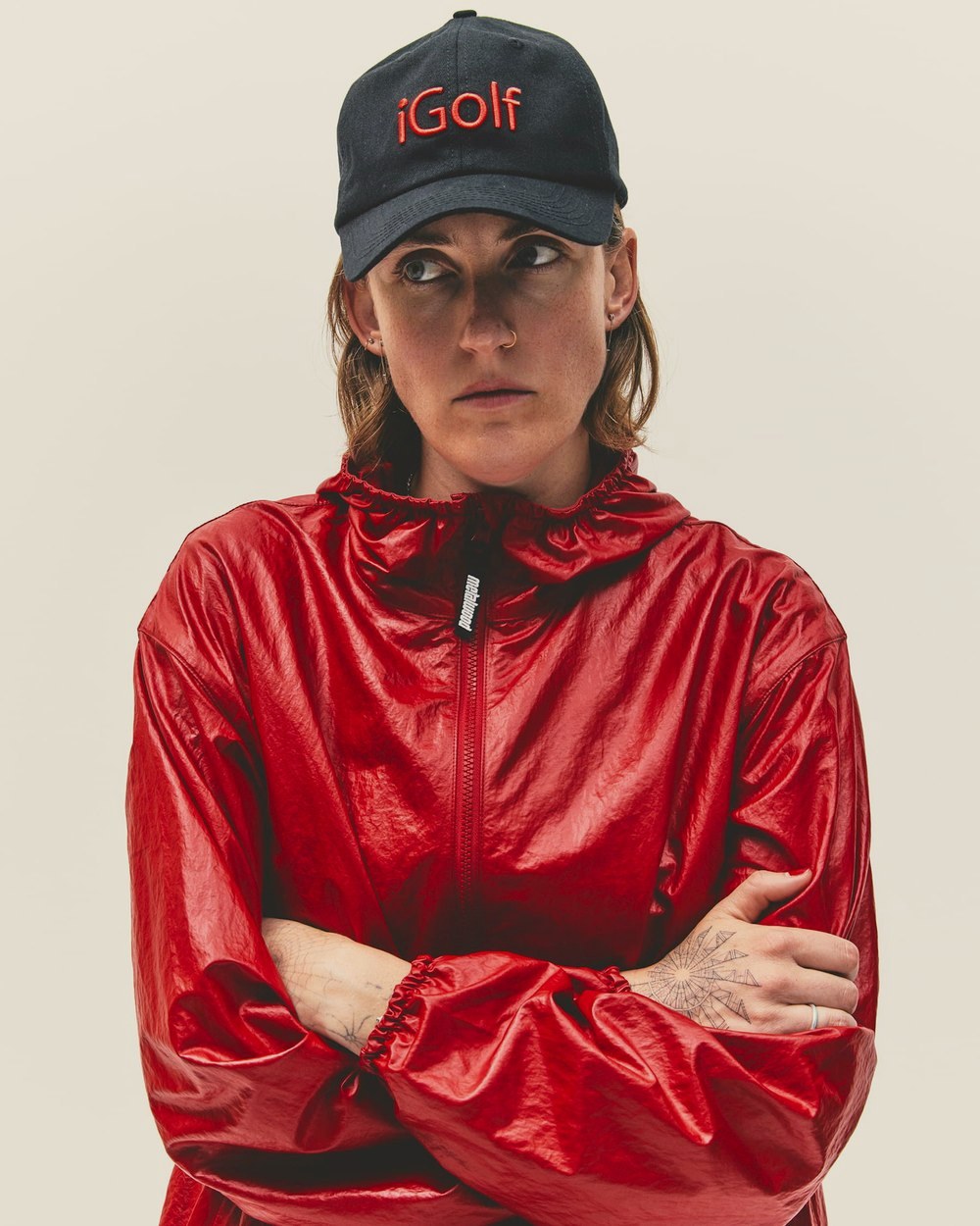 A woman in the ruby Oasis Parka and a red iGolf hat