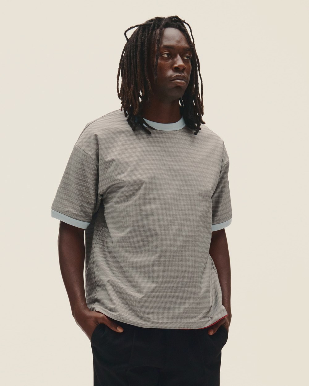 A man in a gray striped tee with contrast ribbing