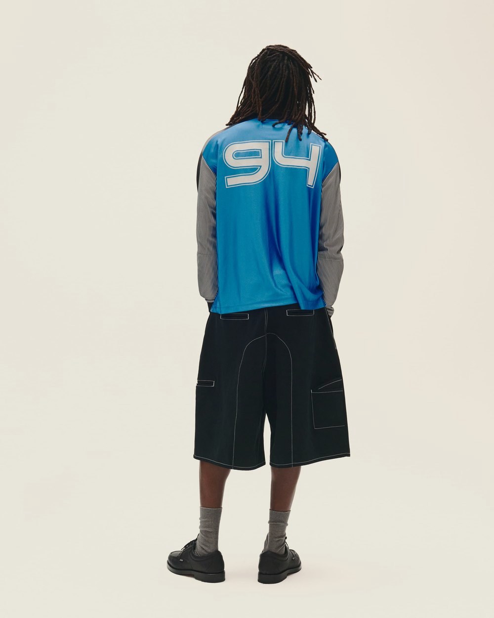 A man seen from behind in the blue Goalie Jersey with 94 on the back and black shorts
