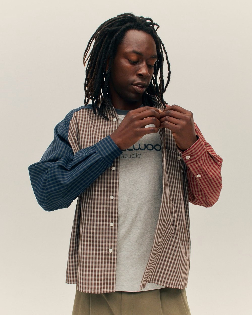 A man buttoning the patchwork Frankenstein Button Up Shirt