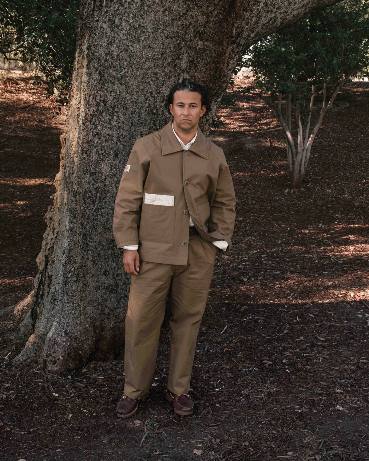 A model in the ripstop work jacket and pants under a tree