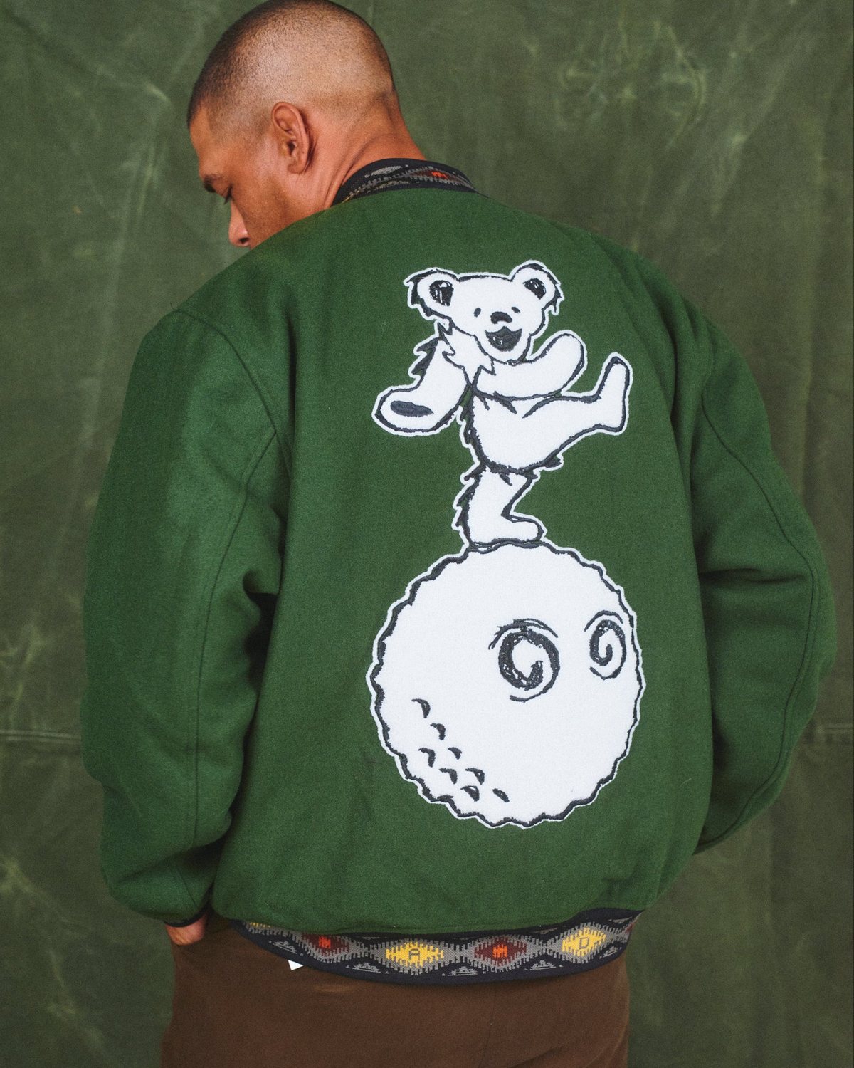 The back of the Malbon x Grateful Dead varsity jacket with the dancing bear on a golf ball, from Malbon's campaign