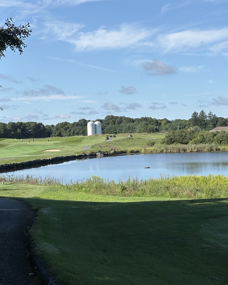 A pond and cart path at The Links at Union Vale with a farm silo on the horizon