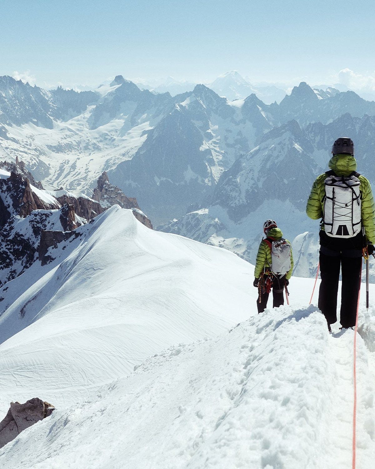 Two hikers roped up on a snowy alpine ridge