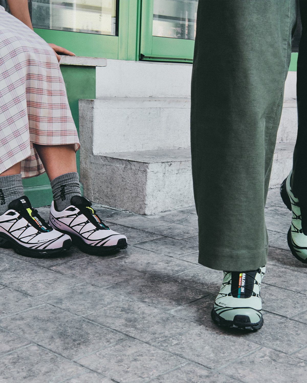 XT-6 shoes worn with wide olive trousers on concrete steps