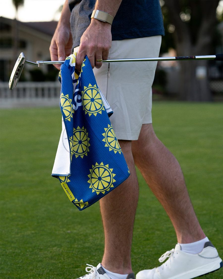 A golfer carrying the Surfside x Palm towel