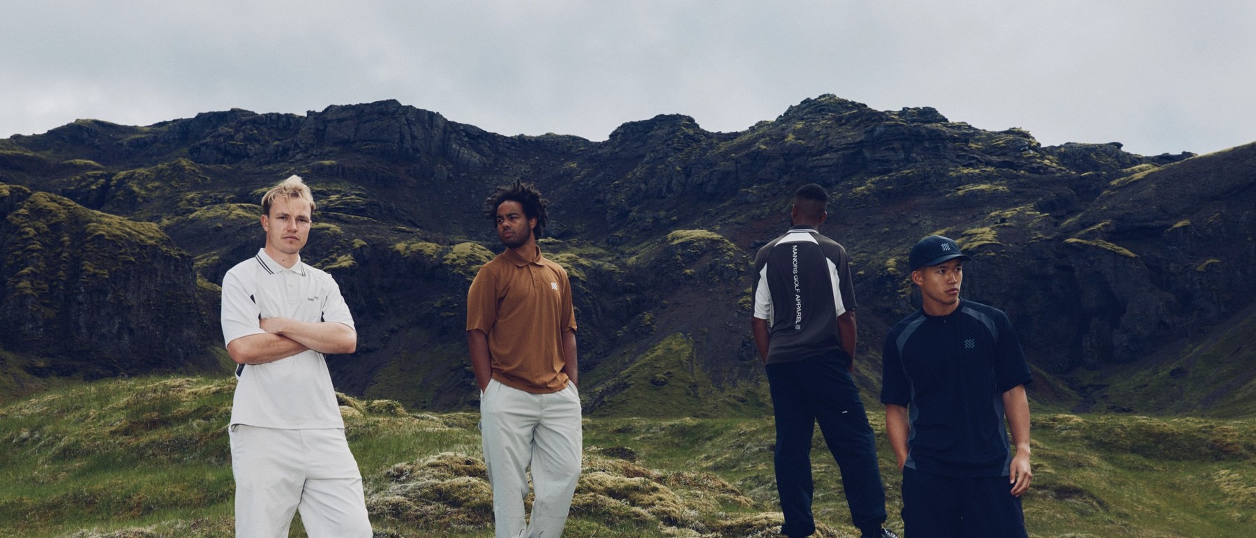 Four golfers on a links headland, three of them in trousers
