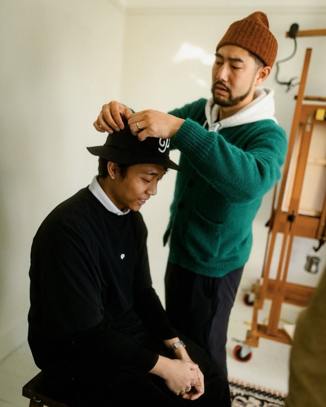 Behind the scenes of a Public Drip campaign shoot, adjusting a hat