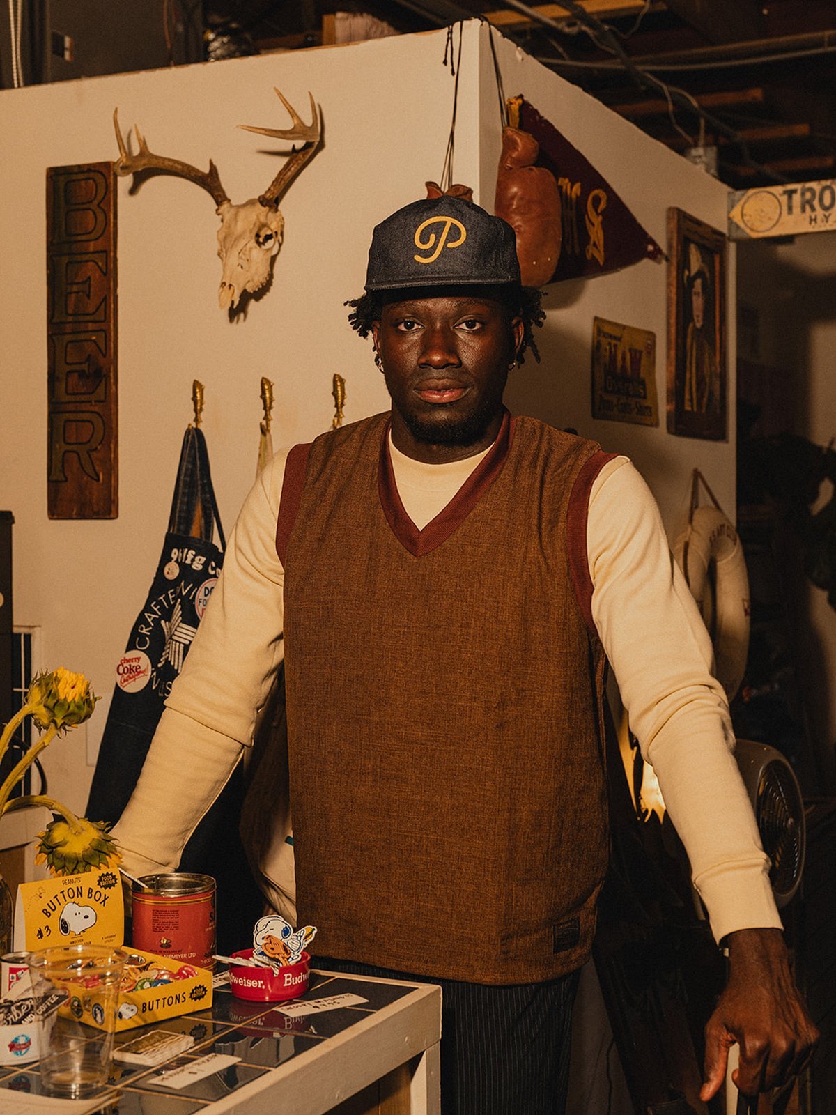 A man in the brown sharkskin swing vest over a cream long-sleeve in a vintage shop