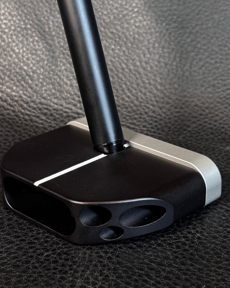 The Machine M12 ZTX mallet converter putter head resting on a dark leather surface