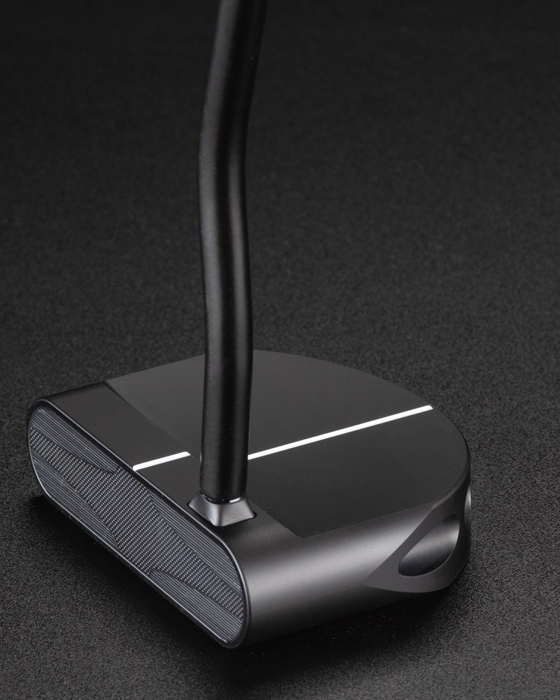 The Makefield Arm Lock putter head at address on a dark studio surface