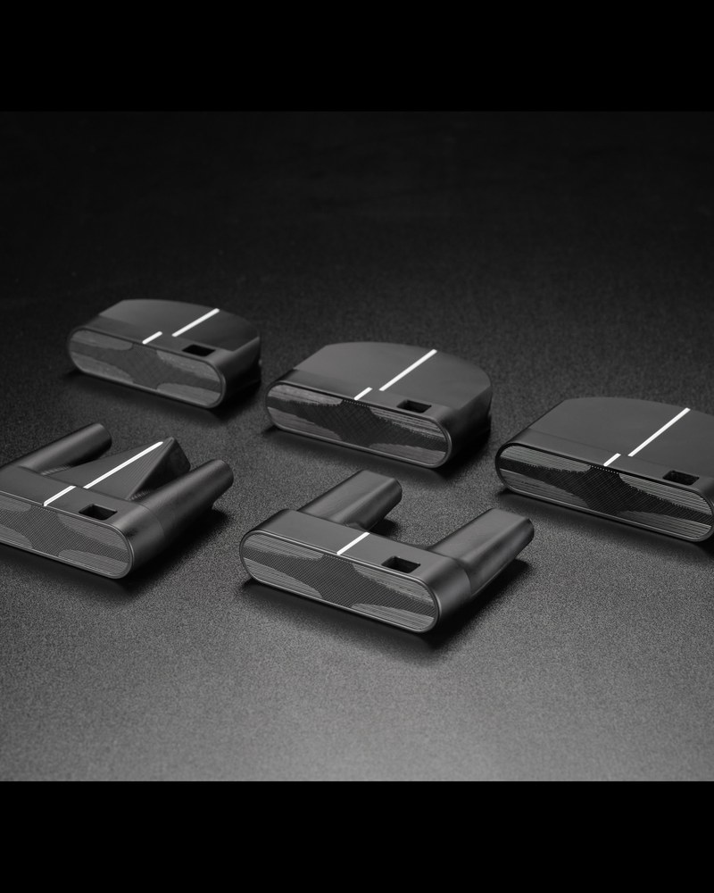 A group of Makefield putter heads laid out on a dark surface showing the shape options