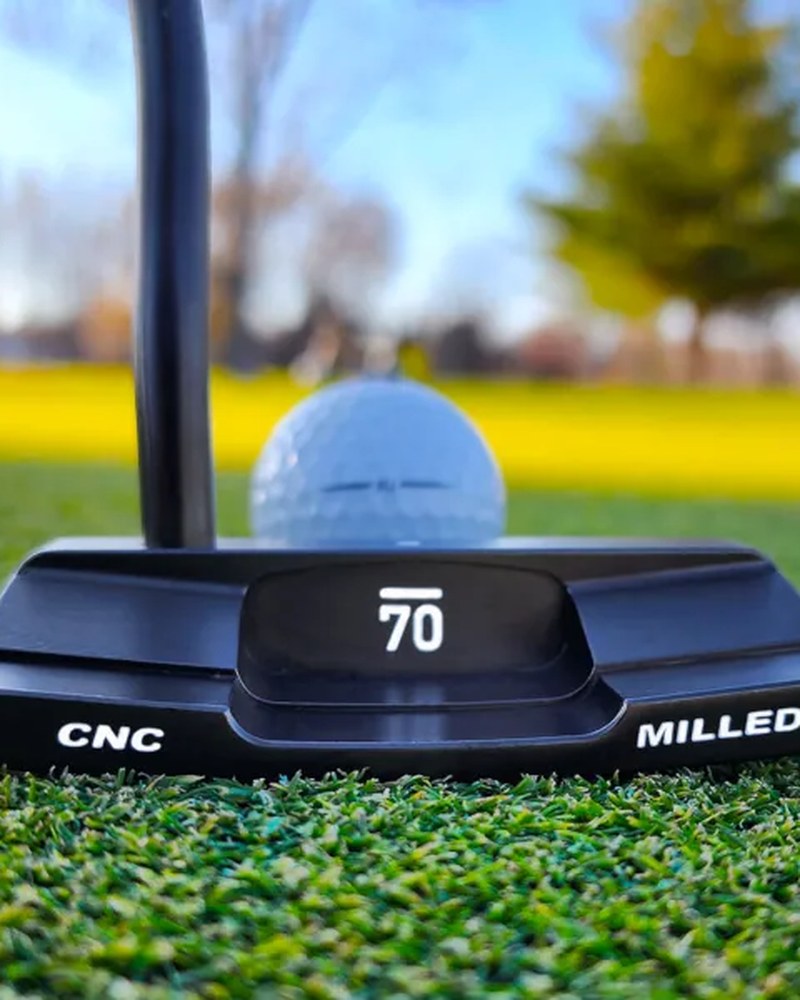 The Sub 70 TAIII 254 wide blade putter on grass showing the CNC milled badging