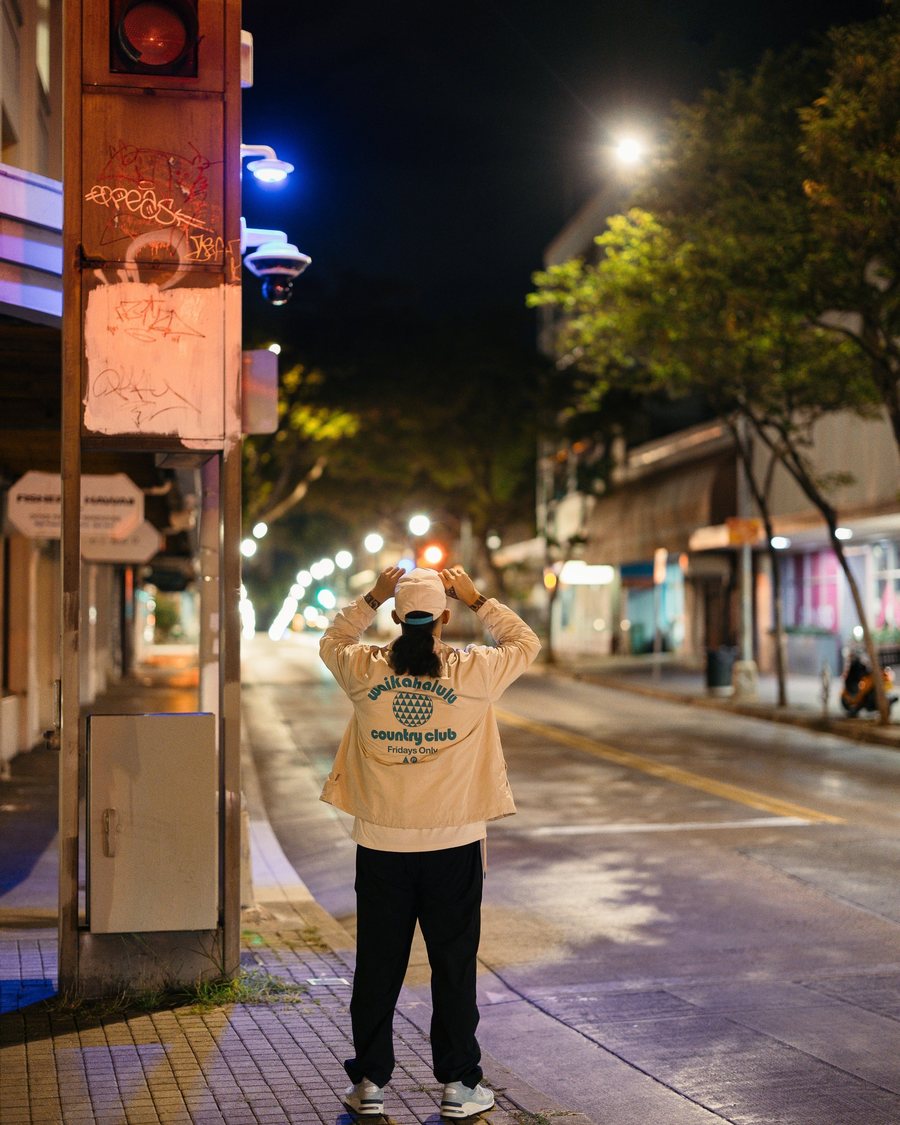 A golfer in the Country Club longsleeve on a Chinatown street at night