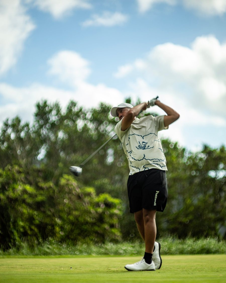 A golfer finishing his swing on a Hawaii course
