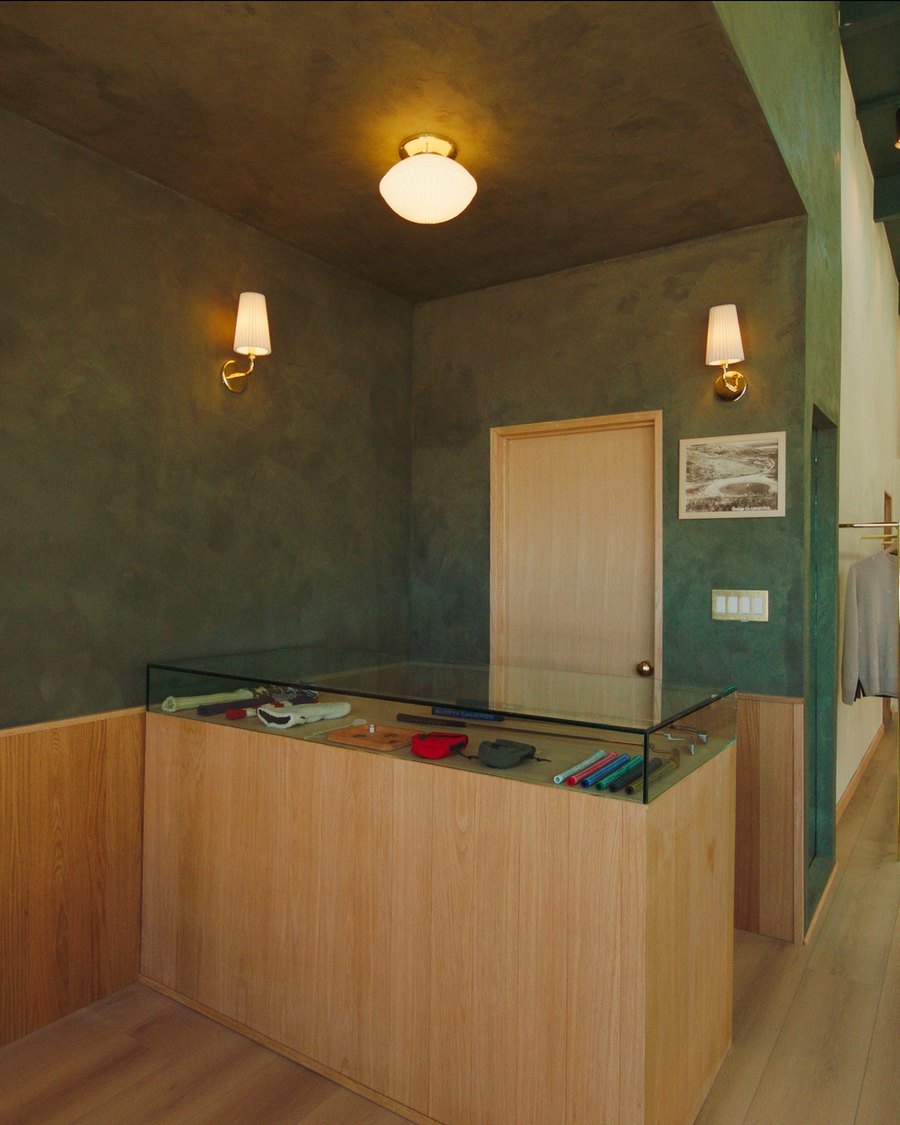 The headcover shadowbox and wood counter inside the Quiet Golf flagship in Costa Mesa