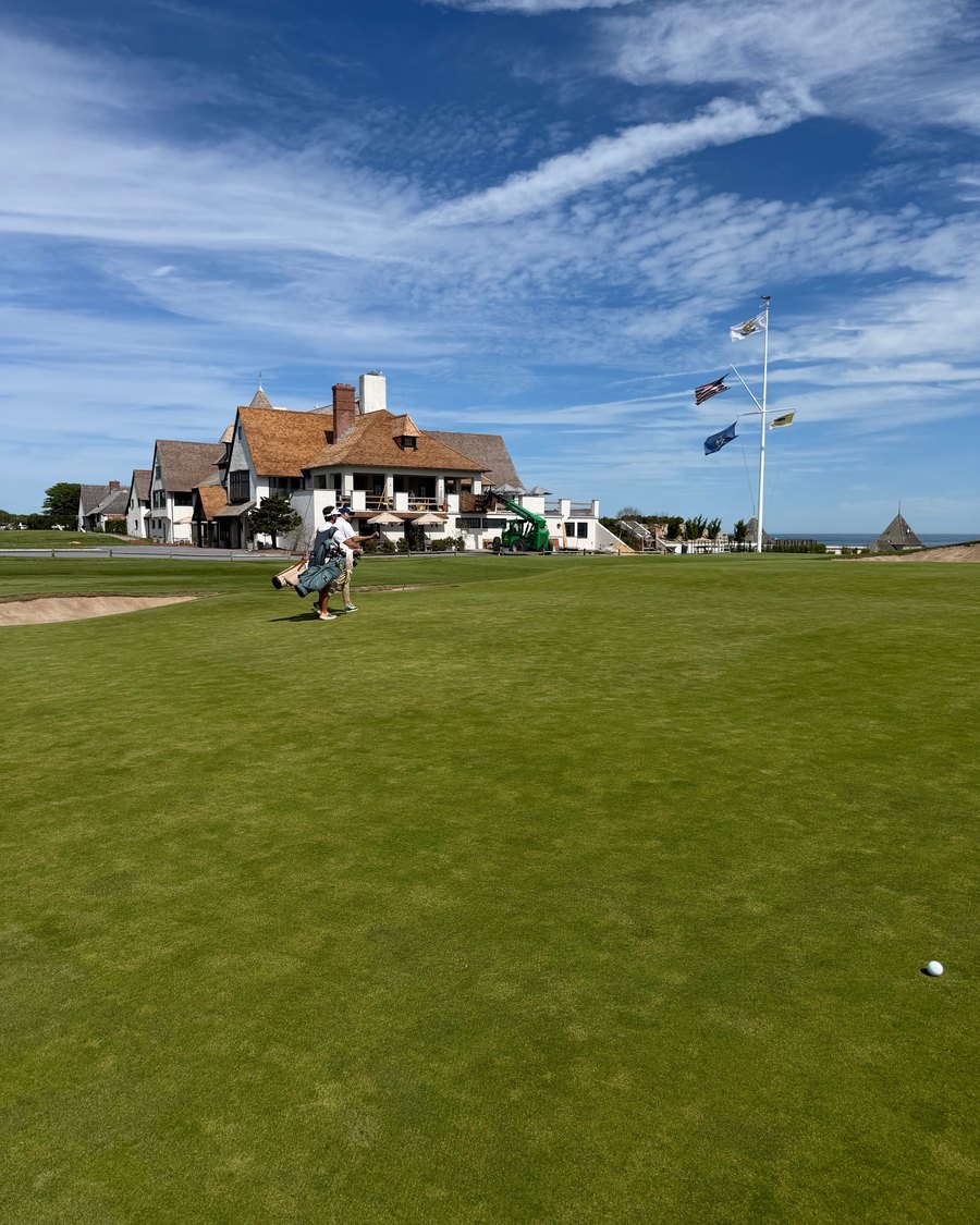 The Maidstone clubhouse beyond a green under a blue sky