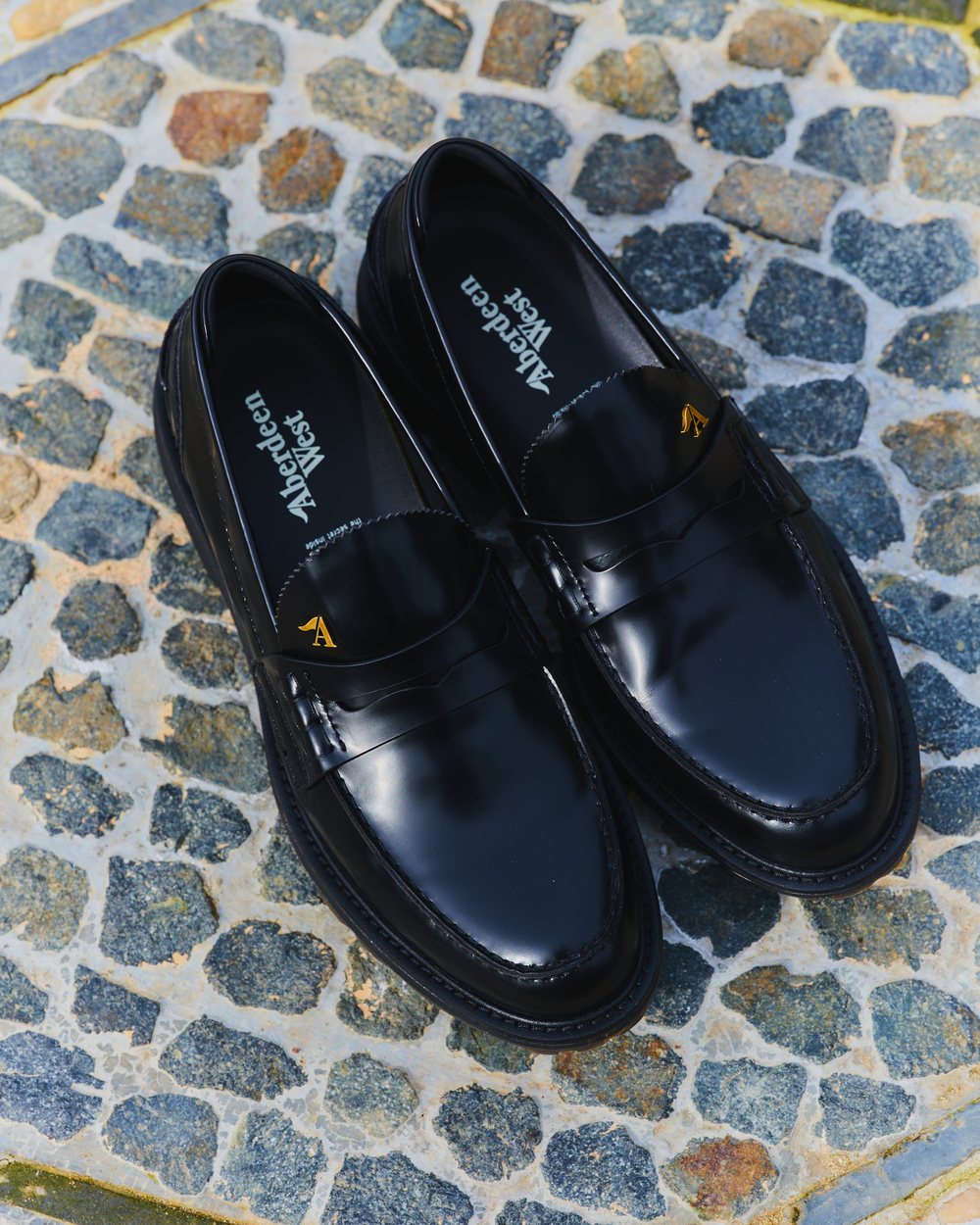 Black Aberdeen West Ghost loafers on a cobblestone path