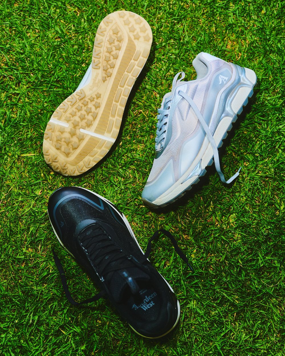 Aberdeen West Harmony golf sneakers in white and black lying on a putting green
