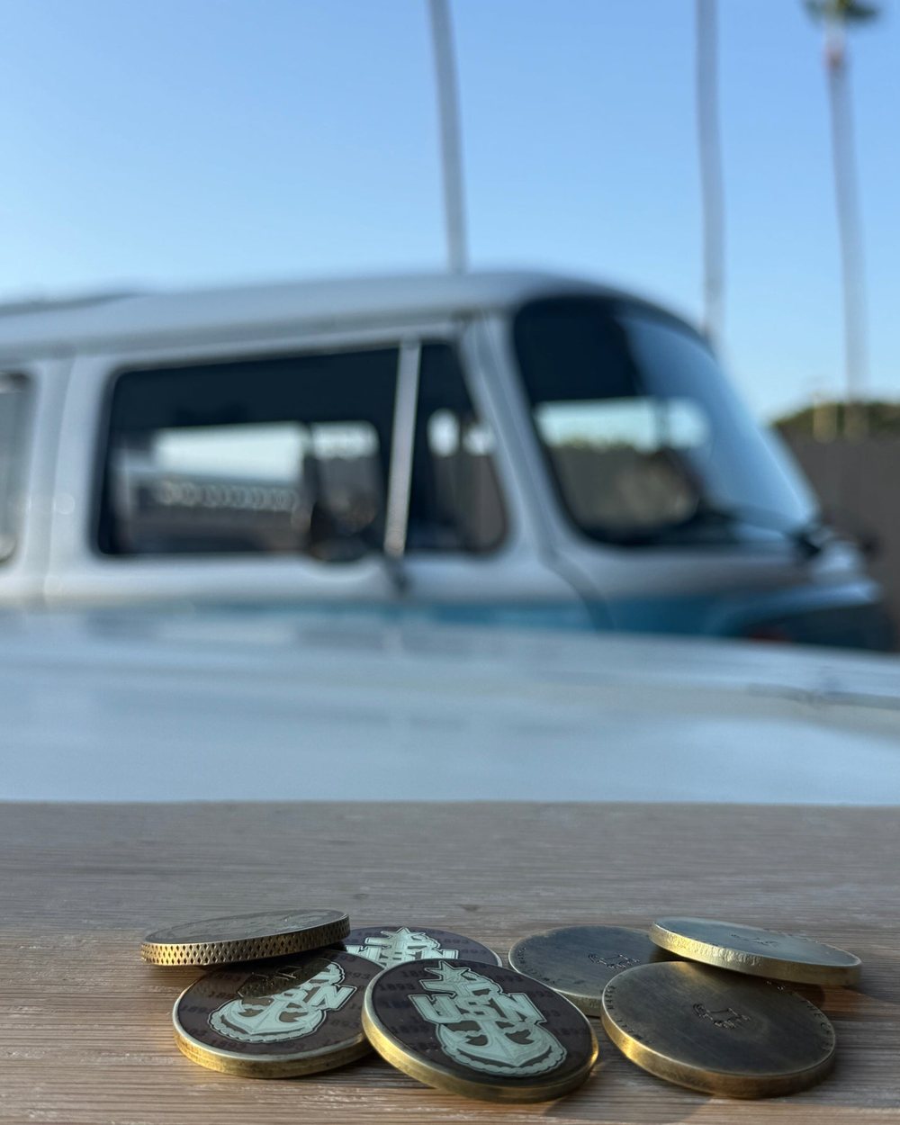 Brass and steel Swell Marks markers lined up on a weathered wooden bench in the garage
