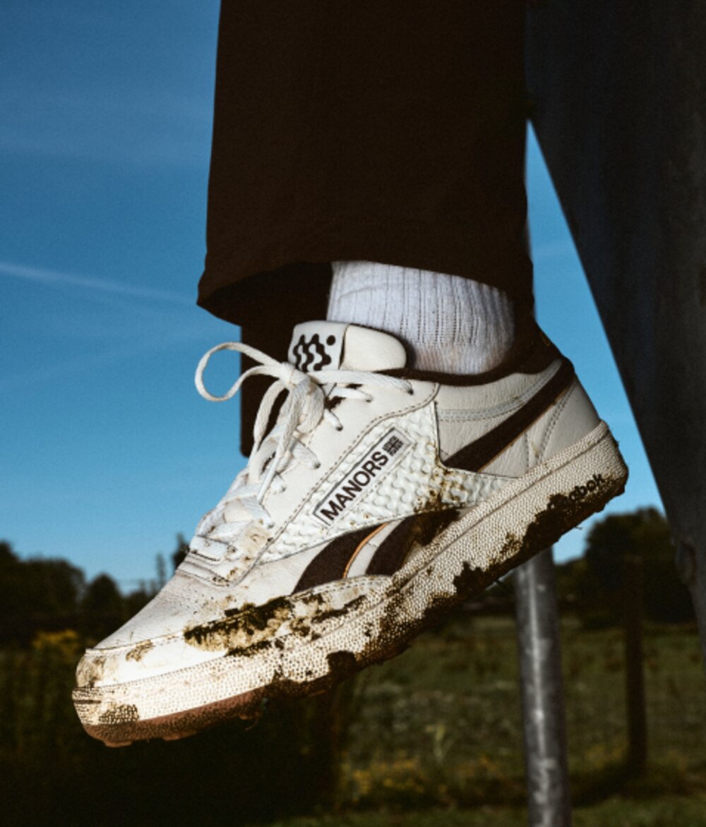 Mud-caked Reebok x Manors Club C Revenge golf shoe on course