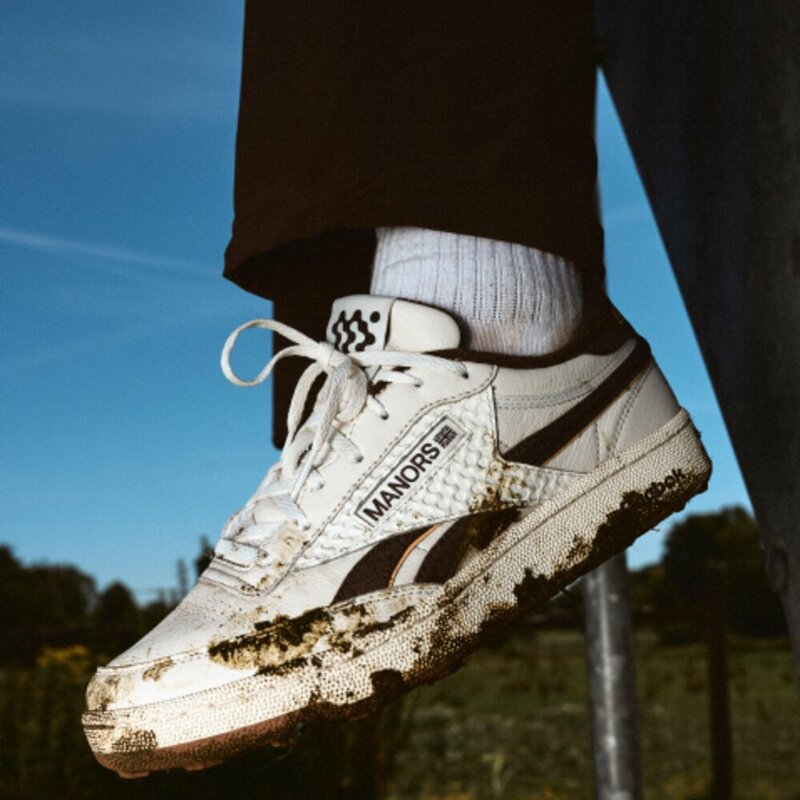 Mud-caked Reebok x Manors Club C Revenge golf shoe on course