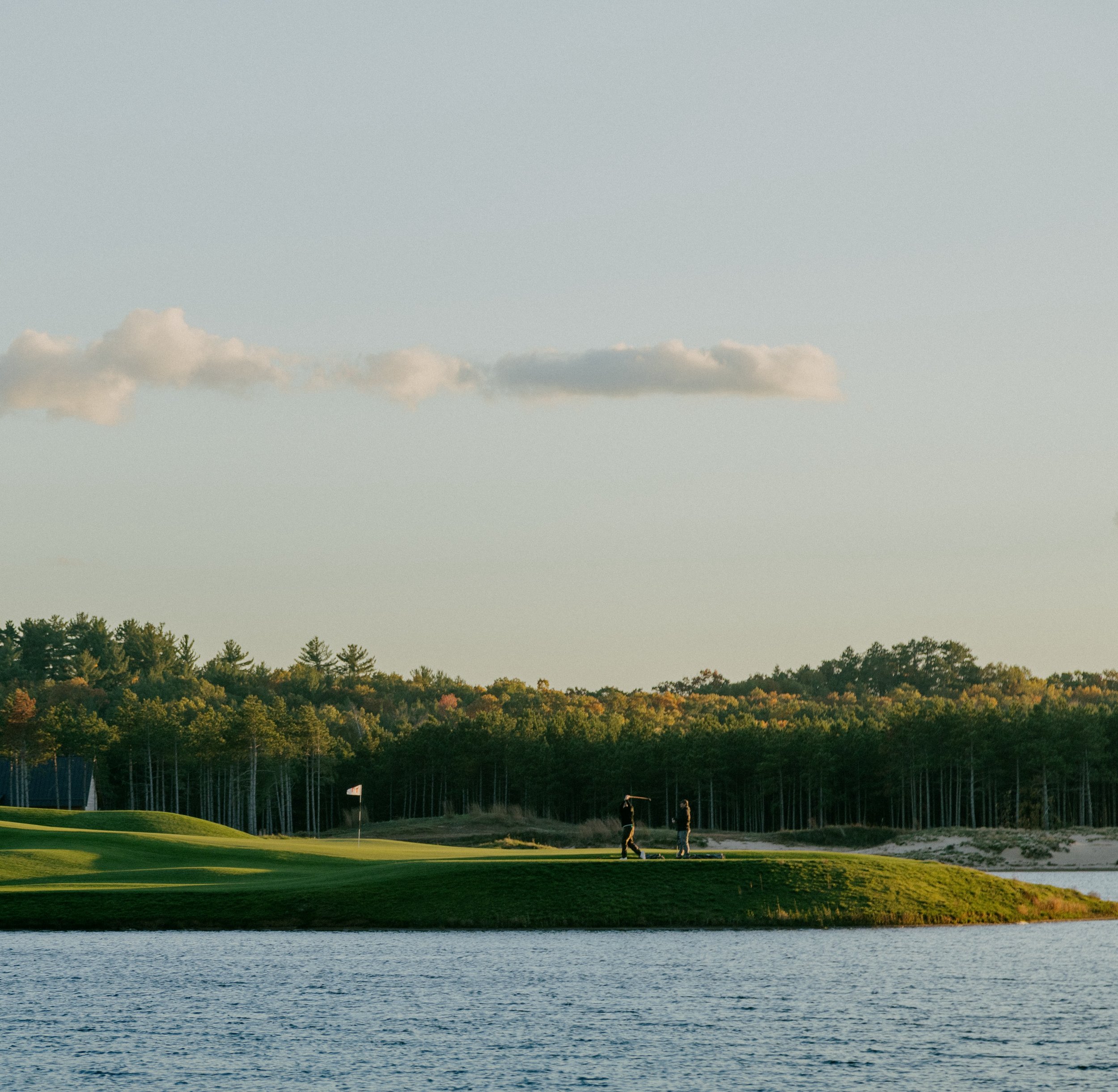A par three across the water at Sand Valley, one walker on the green