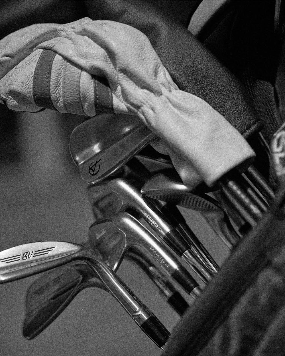 Black-and-white close-up of irons in a golf bag