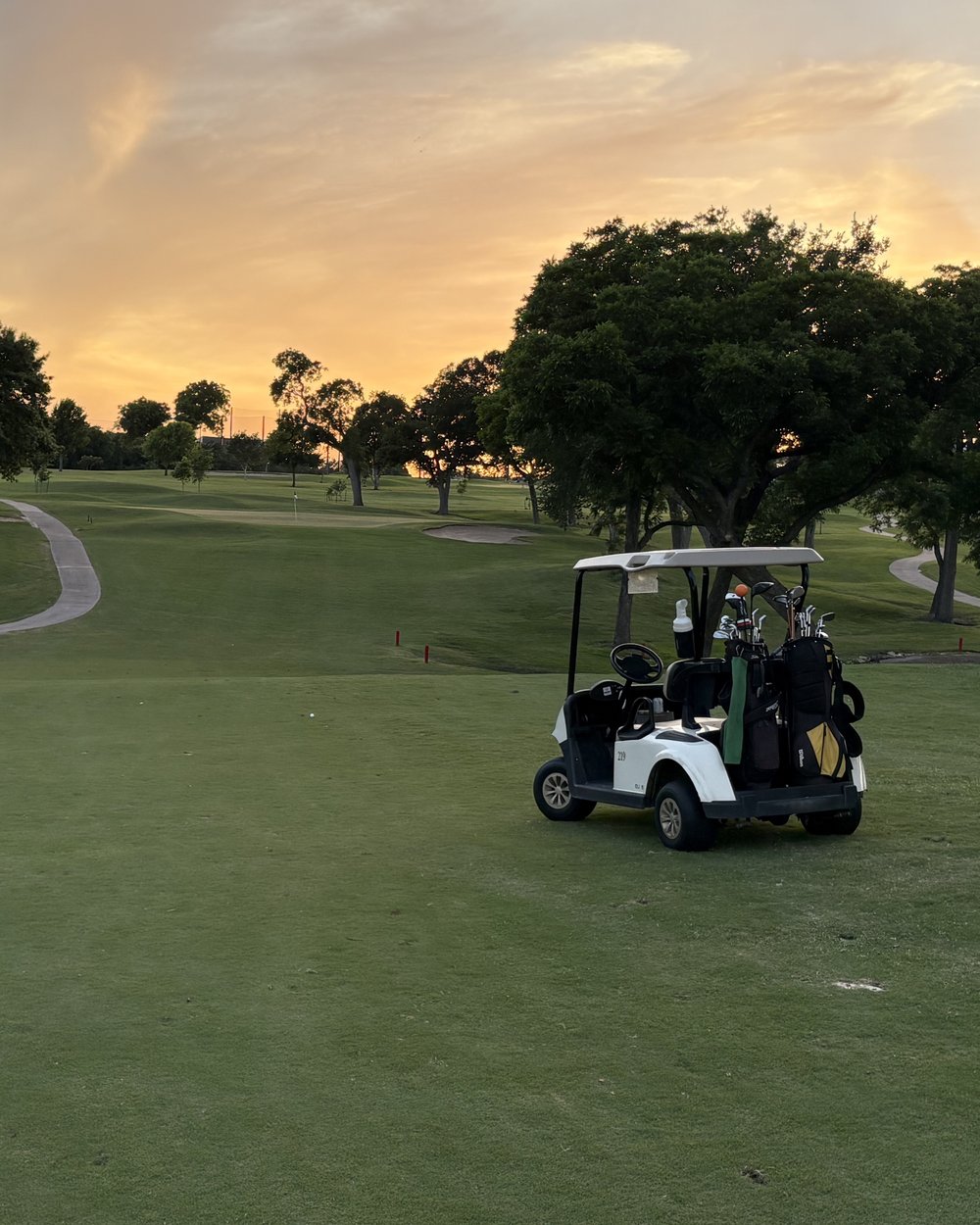 A golf cart parked on the fairway at Morris Williams at sunset