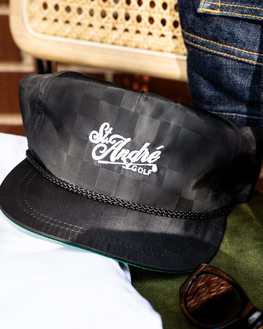 A black St. André rope hat on a rattan chair