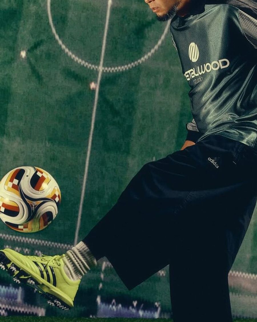 A Metalwood player kicking a ball in the adidas x Metalwood golf shoe