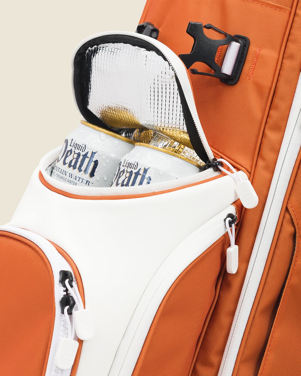 Two cans in the insulated pocket of a burnt orange and white Sunday Golf bag